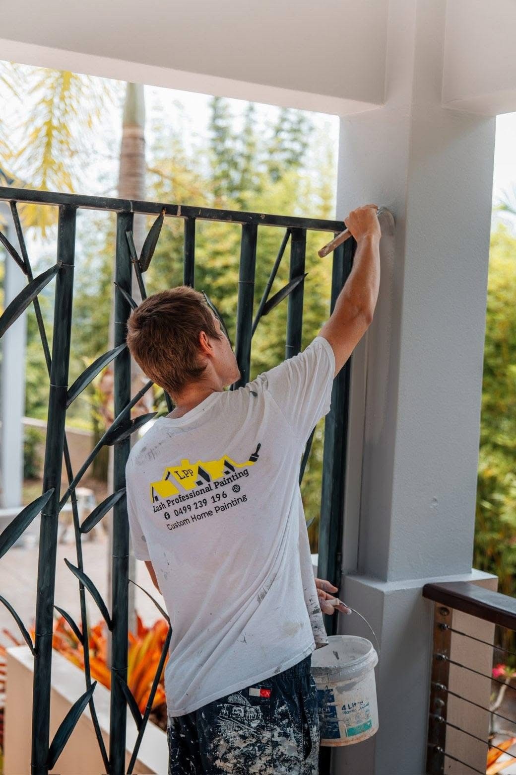 Painter working on exterior fence